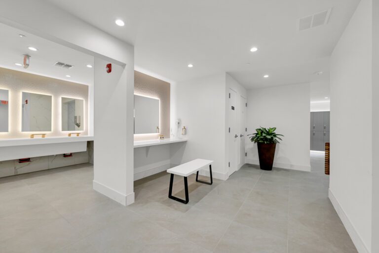 modern fitness center locker room design with illuminated mirrors by Optimal Design Systems International