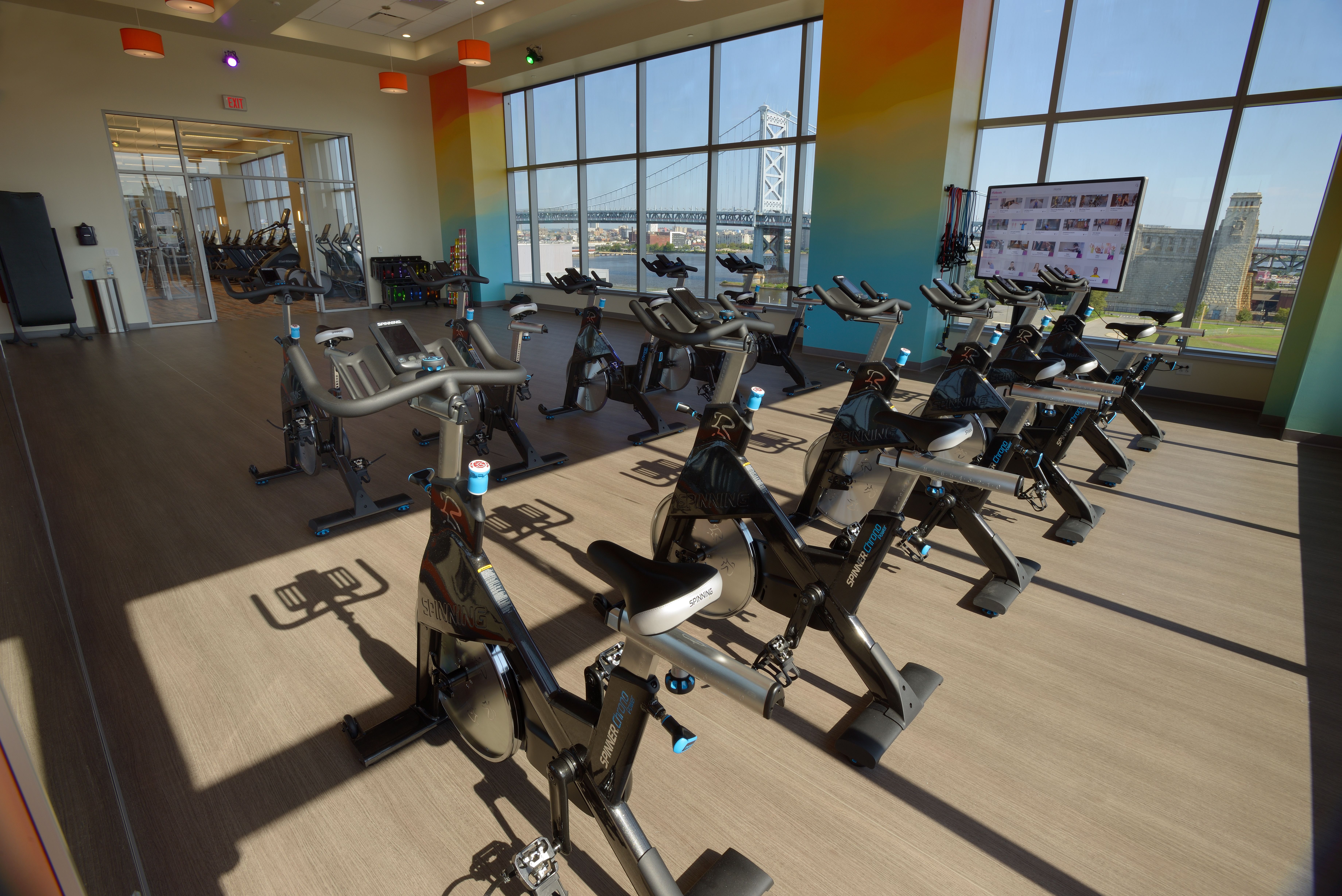 Bright corporate gym with stationary bikes and city bridge view