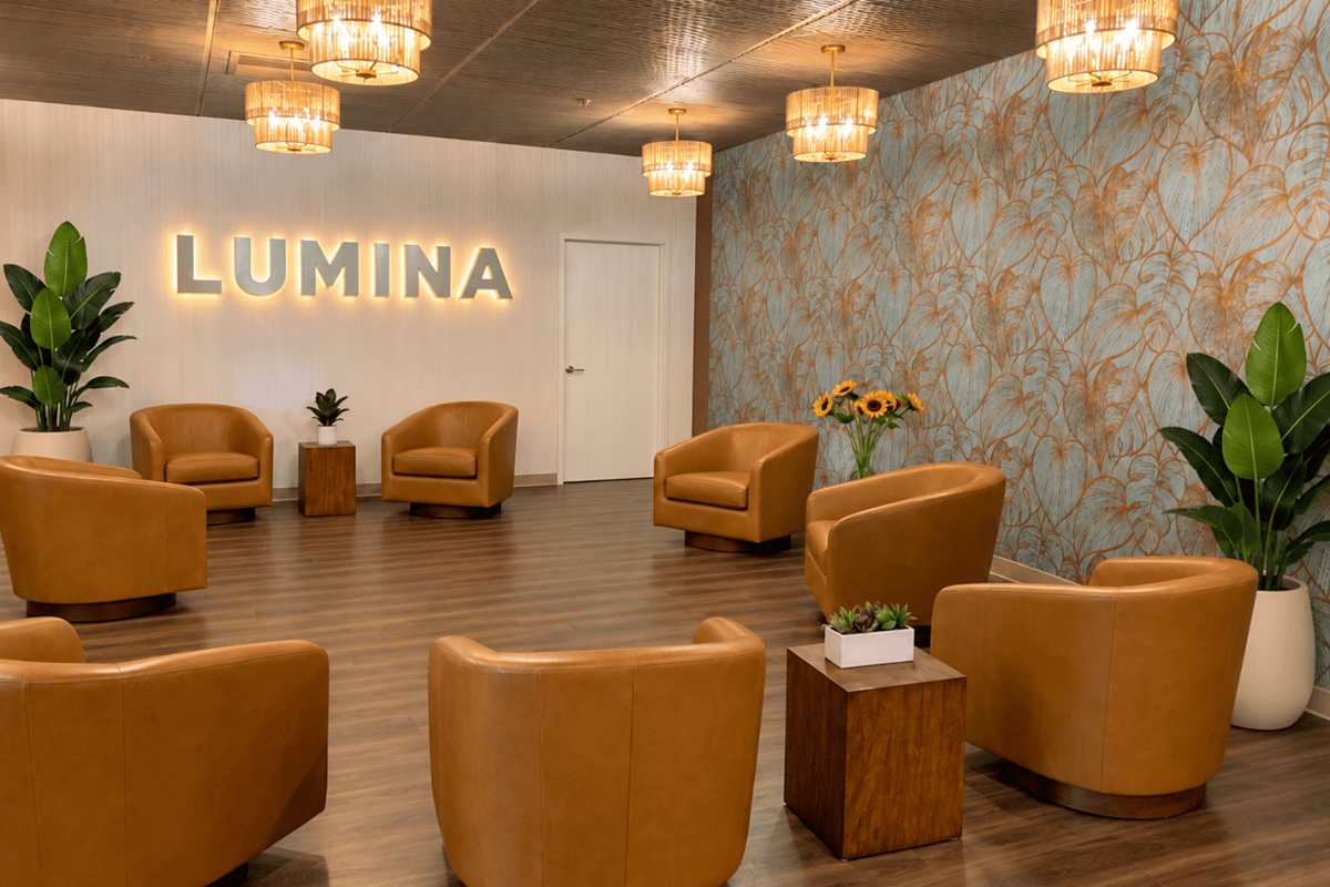 Reception area design of Longfellow Lumina Studio after renovation with back-lit channel letter sign and botanical accent wall.