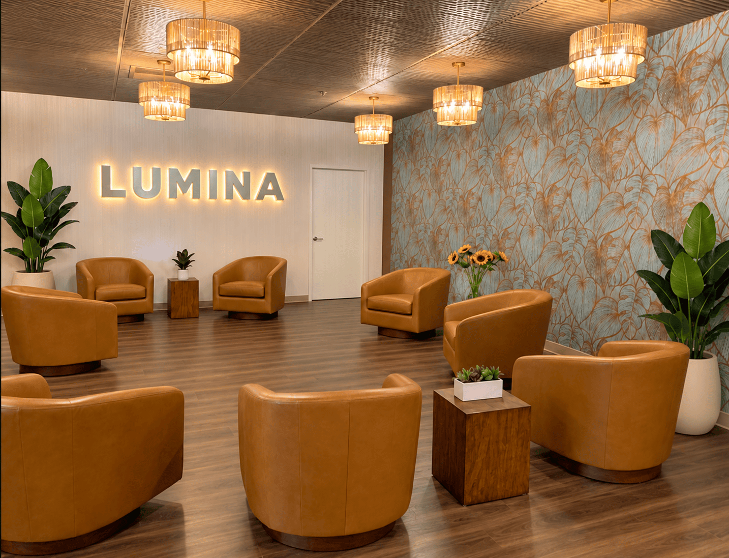Reception area design of Longfellow Lumina Studio after renovation with back-lit channel letter sign and botanical accent wall.