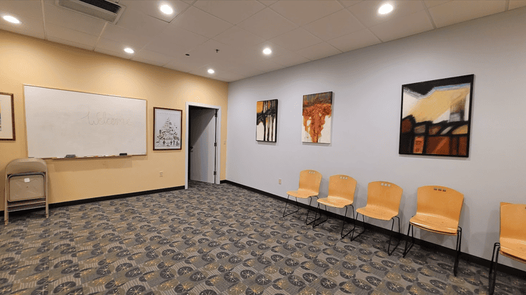 Reception area design of Longfellow Lumina Studio before renovation with dated ceiling tiles, old carpeting, and plain walls.